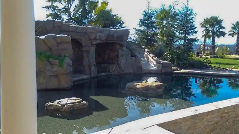 Faux rock grotto and waterfall at the end of a pool