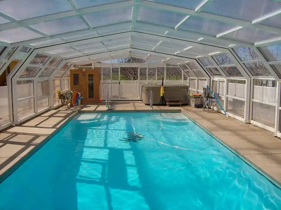 Pool beside a deck with a built enclosure and railing