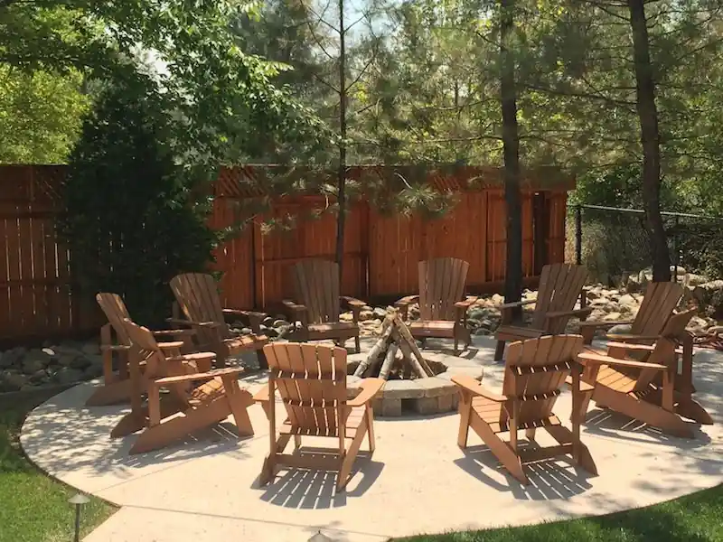 Stone fire pit with seating on a landscaped patio