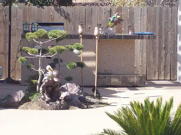 Stone wall with a fountain set into a planted garden