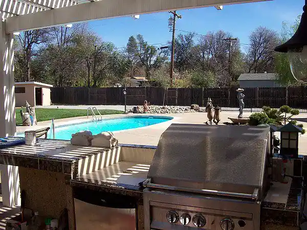 Outdoor kitchen counter in stone beside a patio