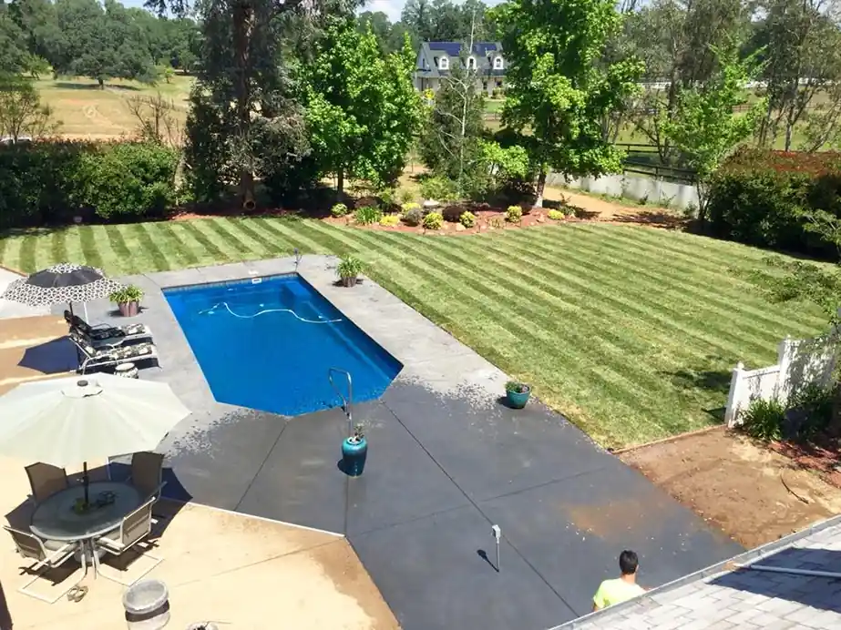 Rectangular pool with a concrete surround set into a green lawn